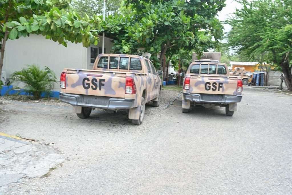 Haïti-Sécurité | Le Premier ministre visite la base de la Force de suppression des gangs à Tabarre 5 Le Premier ministre Alix Didier Fils-Aimé lors de sa visite à la base de la Force de suppression des gangs (FSG) à Tabarre, le 13 mai 2026, en compagnie de la cheffe du BINUH Daniela Kroslak et du représentant spécial Jack Christofidies, devant un véhicule blindé de la mission. | Photo : Primature