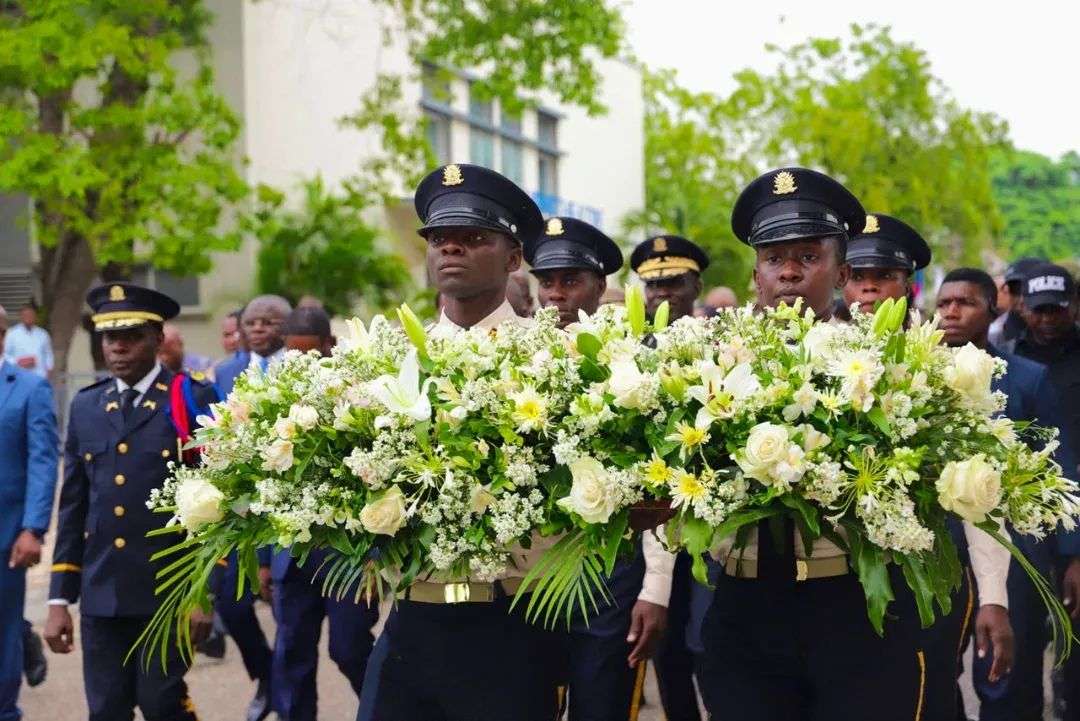 Des policiers de la PNH portent des gerbes de fleurs lors de la cérémonie du 31e anniversaire de l'institution, Port-au-Prince, 12 juin 2026.